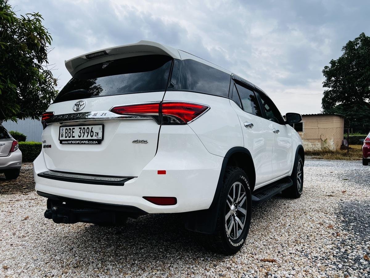 Rear three-quarter view of the white Toyota Fortuner, showing the 4x4 badge and tow bar